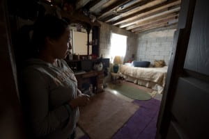 Los Laureles Canyon resident Silvia Rico Medina shows UCI FloodRISE participants her bedroom, which floods when wind-whipped rain blows in sideways through the window. The roof, made from a plastic presidential campaign sign, also leaks. Steve Zylius / UC Irvine